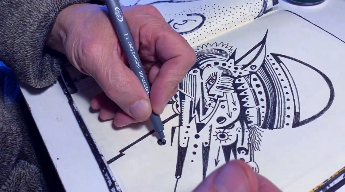 Une main dessine en encre noire sur une page blanche